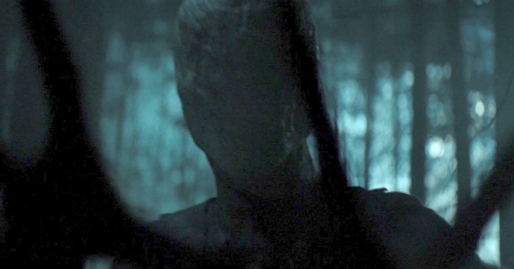Entre galhos, o "rosto" vazio do Slender Man está visível e em foco