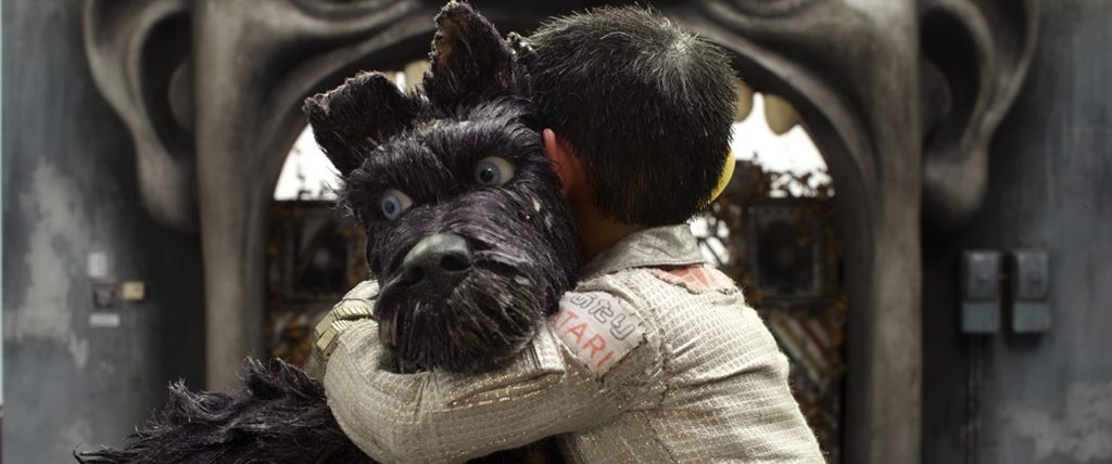 O cão Chief, sendo abraçado por Atari. O cão olha para o lado, confuso.