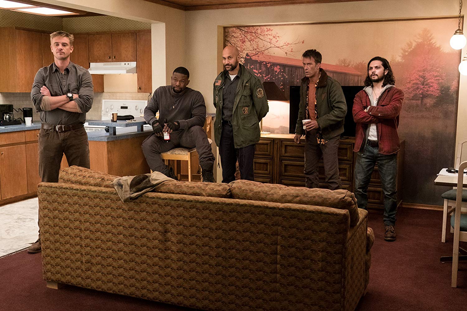 Thomas Jane, Keegan-Michael Key, Boyd Holbrook, Augusto Aguilera, e Trevante Rhodes, na sala de um apartamento, observando algo (ou alguém)