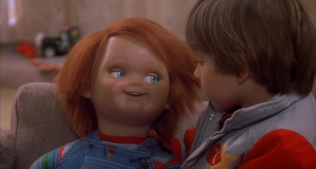 Menino brinca com o boneco Chuck que o olha pacificamente. Maratona de Sofá.