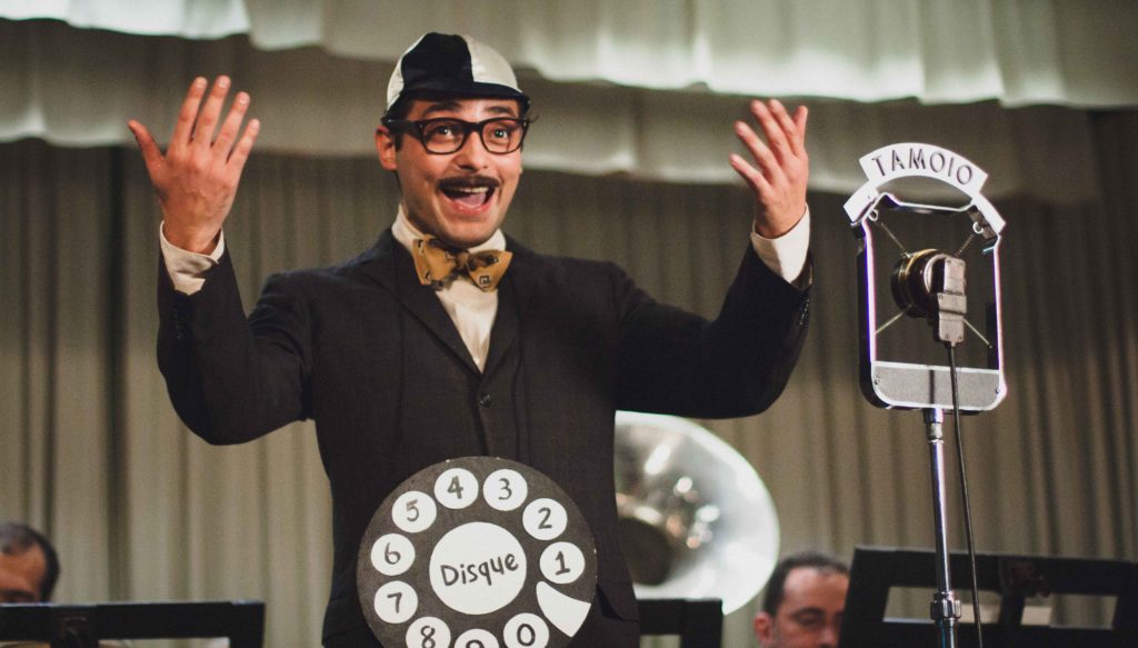 Abelardo Barbosa (Eduardo Sterblitch) no palco da rádio, numa das primeiras fantasias do palhaço Chacrinha