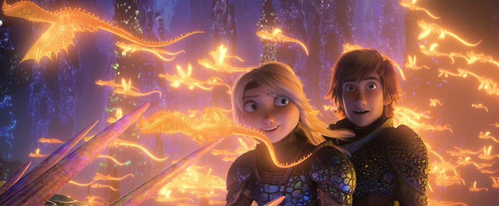 Astrid e Soluço rodeados por pequenos dragões dourados, que voam rente, sem percebê-los.