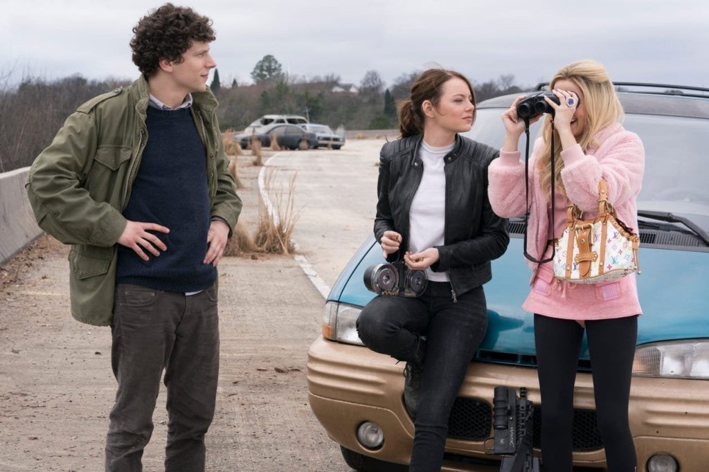 numa estrada, Wichita e Madison (Zoey Deutch) está apoiadas numa minivan azul. Madison está olhando num binóculo virado ao contrário. Wichita está olhando para ela com um divertimento cruel. Columbus está em pé, à esquerda, olhando para ela com um riso meio feliz, meio constrangido