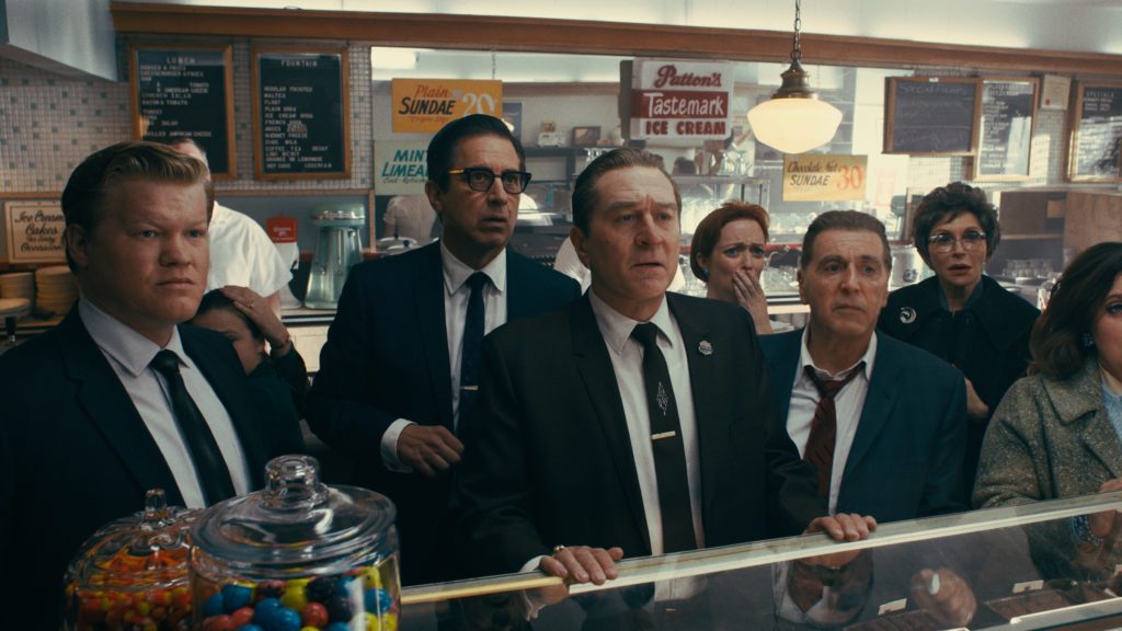 Frank e outros personagens olhando para uma TV fora de cena