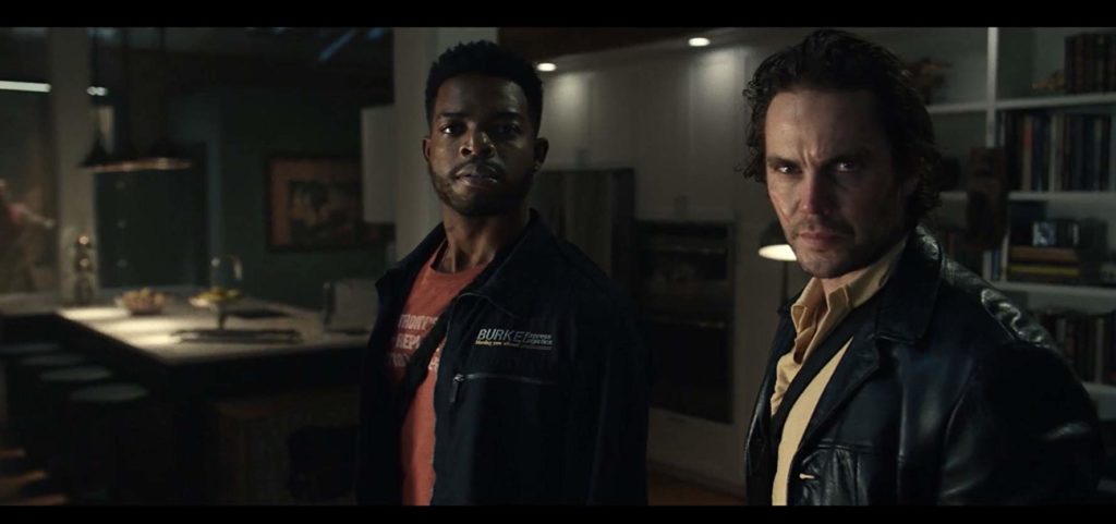 MIchael (Stephan James) e Ray (Taylor Kitsch), em pé numa cozinha, olham para atrás da câmera. parecem tensos.