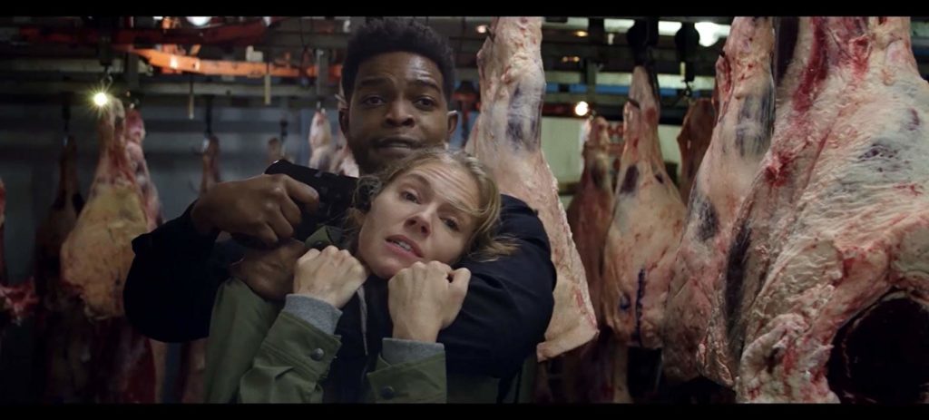 Michael está enforcando Frankie (Sienna Miller) e apontando uma arma para sua têmpora. ele não parece com raiva, mas sim preocupado. ela parece cansada e desesperada. Eles estão dentro de um frigorífico, com peças de carne penduradas