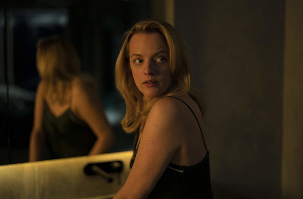 Elisabeth Moss (Cecília) de frente para um espelho, olhando para trás.