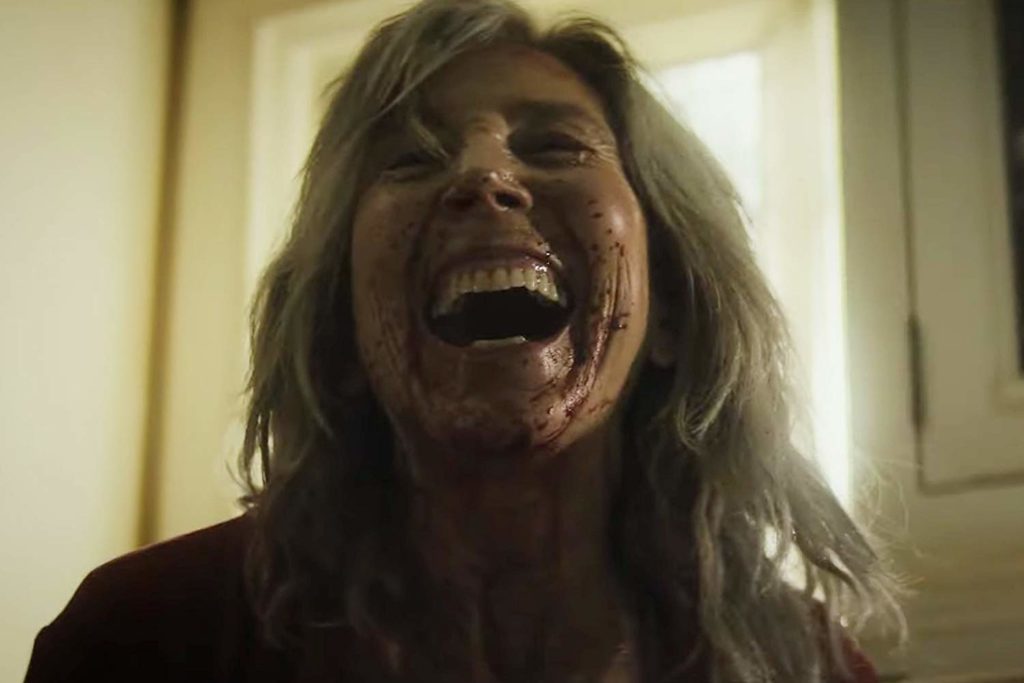 Em close, Faith Matheson (Lin Shaye) gargalha. Seu rosto está todo ensanguentado