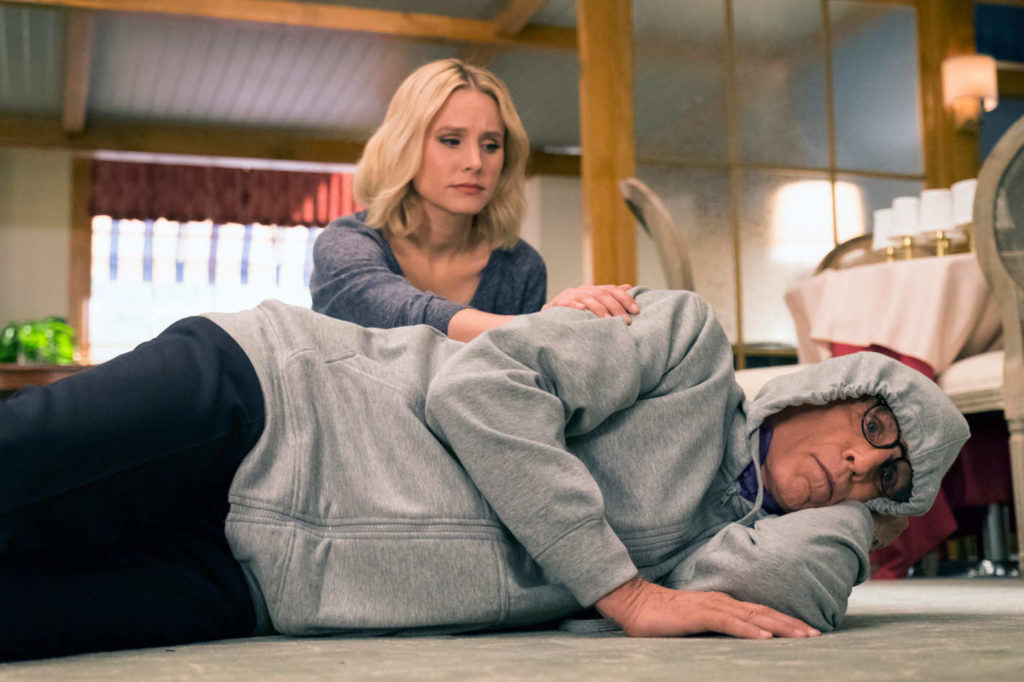 michael desolado no chão com um casaco, enquanto eleanor o consola em The Good Place
