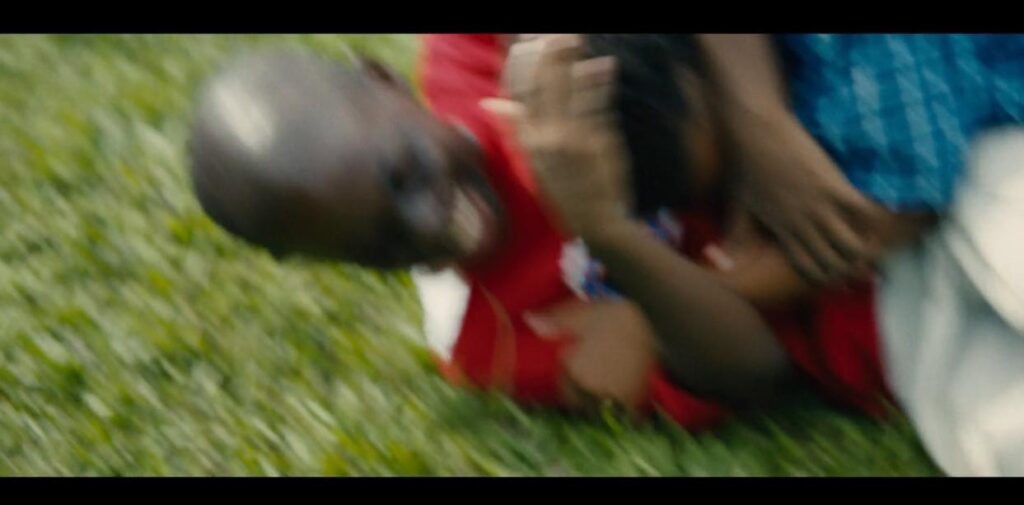 Cena de Moonlight: Deitados na grama, Chiron e Kevin se agarram, um tentando dar um mata-leão no outro. A cena está borrada, pela movimentação 