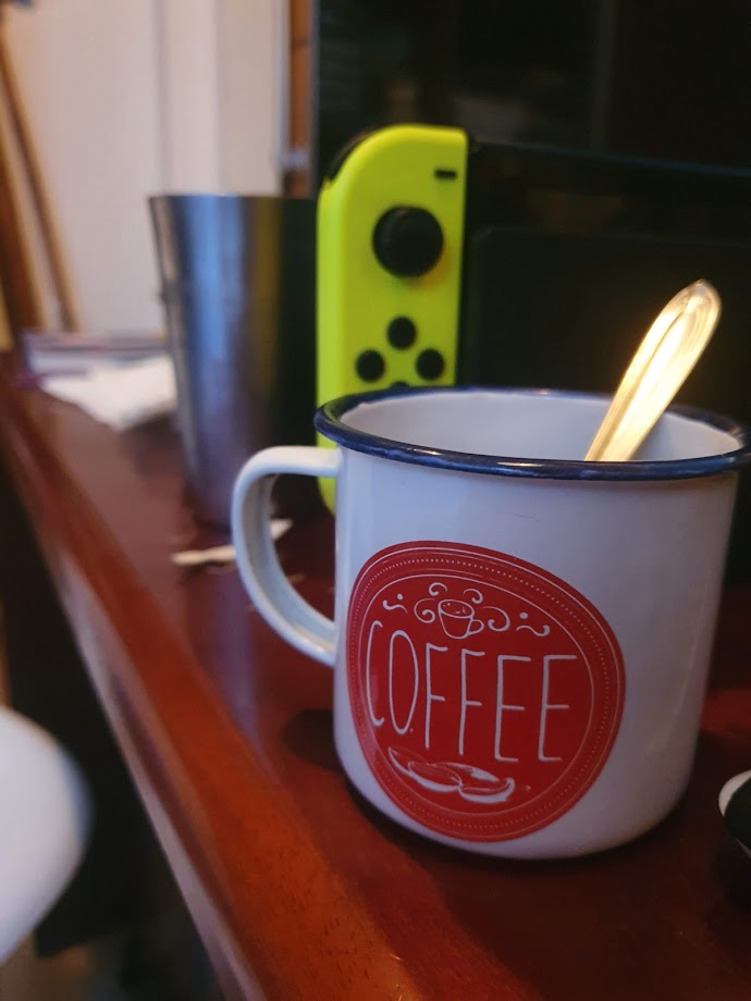 Foto de uma mesa com uma xícara de café em primeiro plano