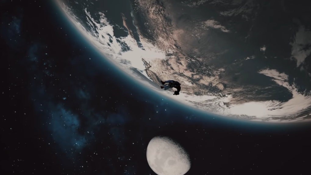Imagem semelhante ao poster. Criança negra flutuando no espaço. Terra e Lua ao fundo.