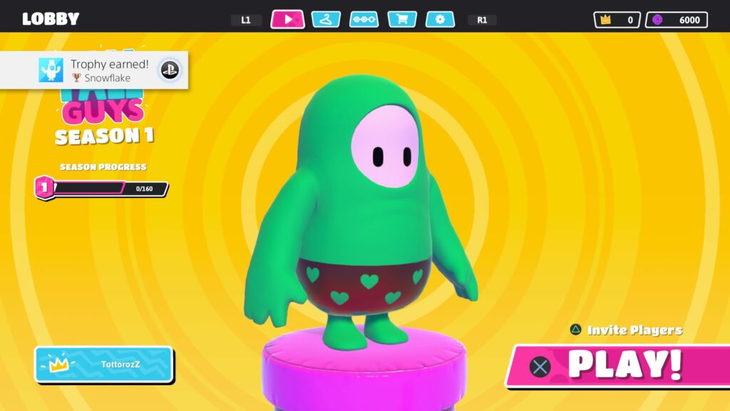 Tela de início de jogo de Fall Guys que consiste em seu personagem em primeiro plano, e algumas opções como iniciar o jogo, convidar jogadores, ou navegar entre algumas opções do jogo.