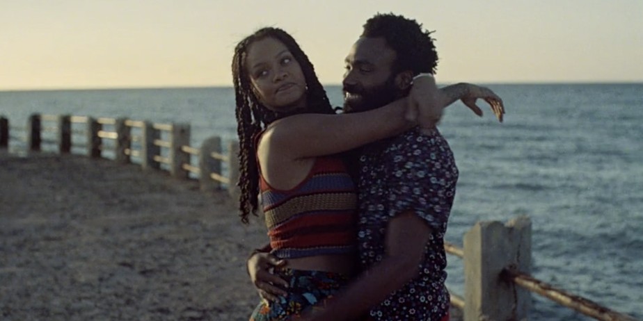 Rihanna e Donaldo Glover se abraçam à beira-mar em cena do filme. 