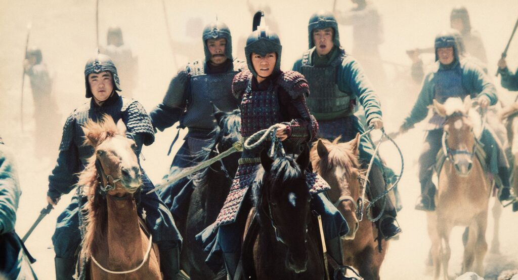 Num terreno desértico, Mulan está sobre seu cavalo, vento negro. Diversos homens a seguem, muitos com espada em punho. Ao fundo, pode-se ver uma fileira de arqueiros
