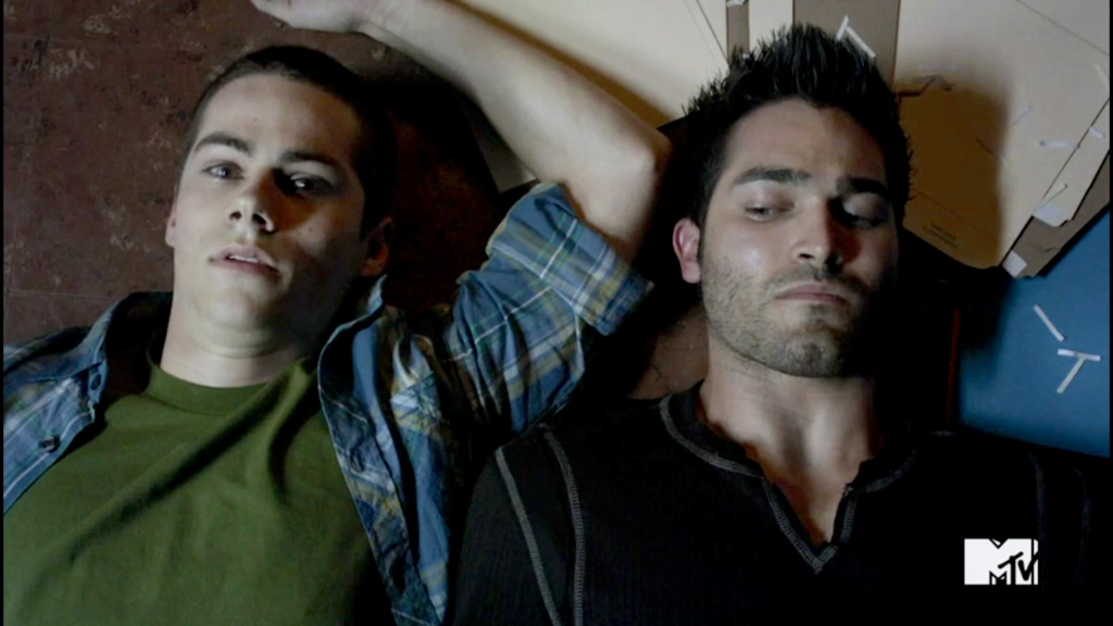 Derek e Stiles do seriado Teen Wolf deitados no chão da delegacia.
