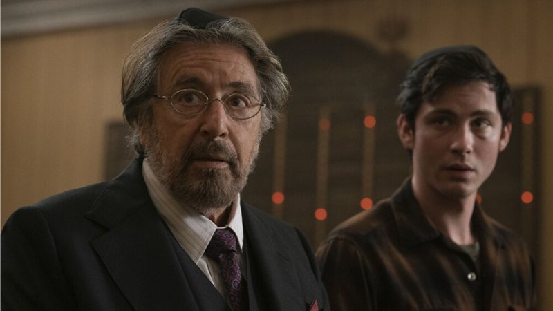 Al Pacino, que interpreta Meyer Offerman, está ao lado de Logan Lerman, intérprete de Johan Heidelbaum, em uma sinagoga.