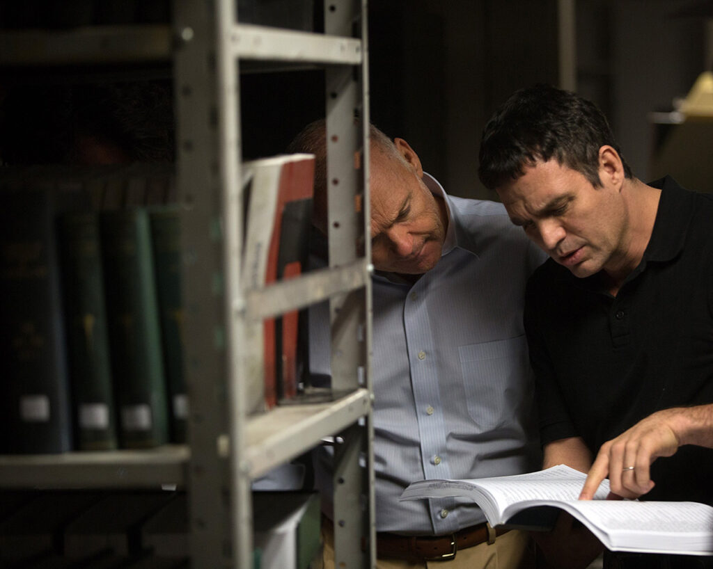 Rezendes e Walter no subsulo da livraria, lendo registros das igrejas locais em Spotlight