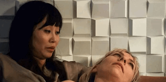 Bess e Jinju estão deitadas numa cama de casal. Jinju fala alguma coisa, que surpreende Bess, que se senta para olhar Junji de frente, e a beija