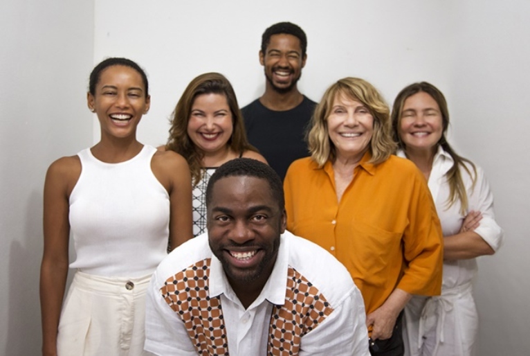 Imagem de vários dos atores principais de Medida Provisória. Na frente, Lazaro Ramos. Na segunda fila, Tais Araújo, Mariana Xavier, Renata Sorrah, Adriana Esteves. Ao fundo, Alfred Enoch. Eles estão em frente a uma parede branca.