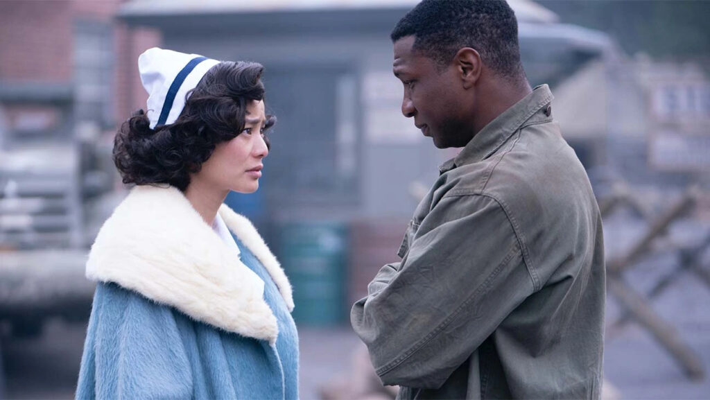 Atticus (Jonathan Majors) e Ji-A (Jamie Chung) em cena de Lovecraft Country, olhando um para o outro, dentro de uma base militar.